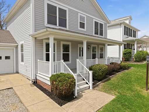 A house with a grey siding and white trim.