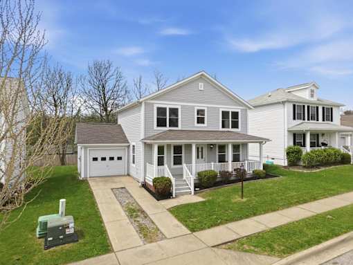 A two-story house with a garage and a driveway.