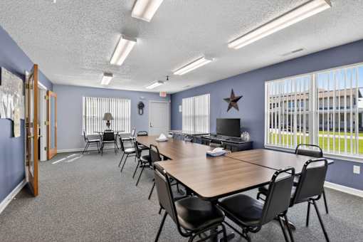 A conference room with a long table and chairs.