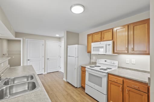 a kitchen with white appliances and wooden cabinets
