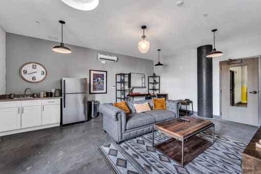 a living area with a couch coffee table and a refrigerator