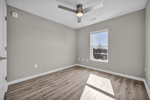 A room with a ceiling fan and a window.