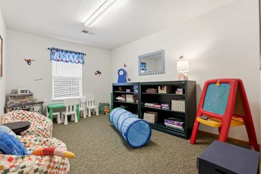 A child's playroom with a variety of toys and furniture.