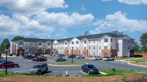 a parking lot with cars in front of an apartment building