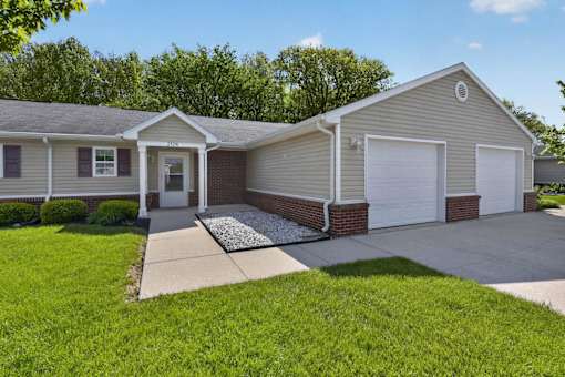 A house with a grey roof and a white garage door.