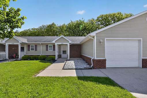 A house with a white garage door and a brick chimney.