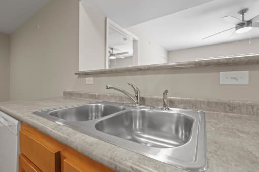 a kitchen with a stainless steel sink and a mirror