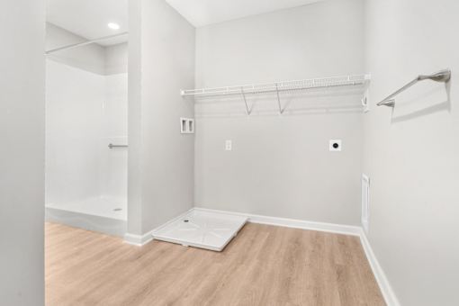 a white room with a wood floor and a white closet
