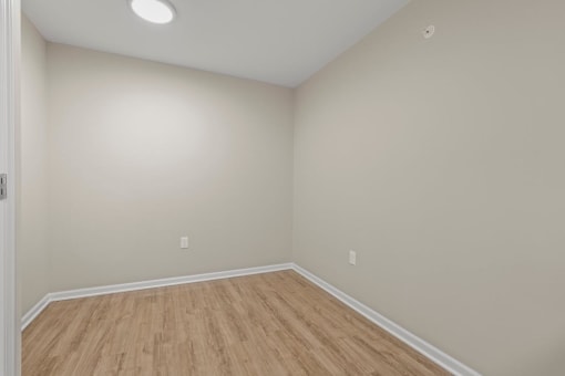 an empty room with wood floors and white walls