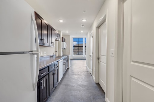 a kitchen with black cabinets and white appliances