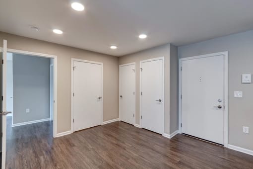 a bedroom with two doors and a hardwood floor