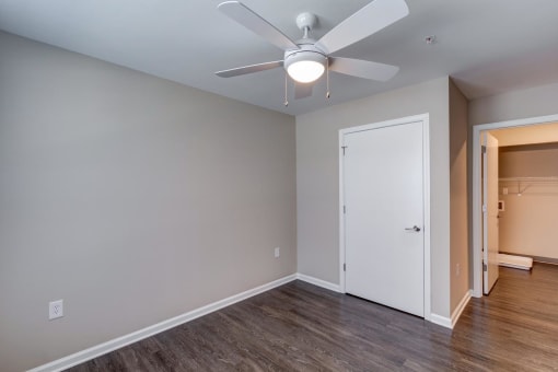 a bedroom with hardwood floors and a ceiling fan