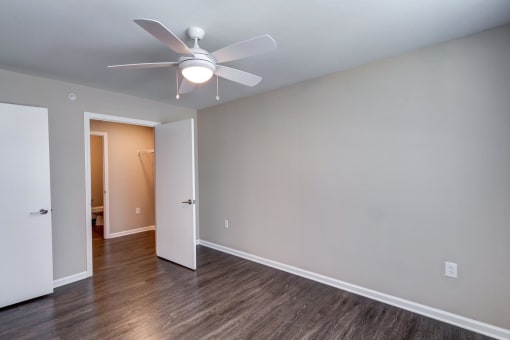 a bedroom with a ceiling fan and hardwood floors