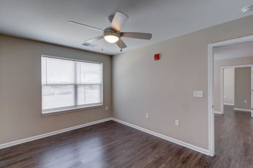 a bedroom with hardwood floors and a ceiling fan