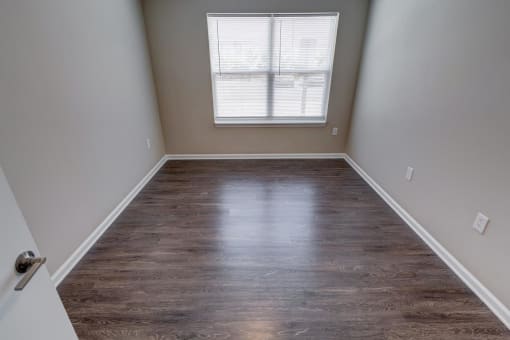 an empty room with a window and a door