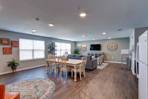 a living room and dining area with a large clock on the wall