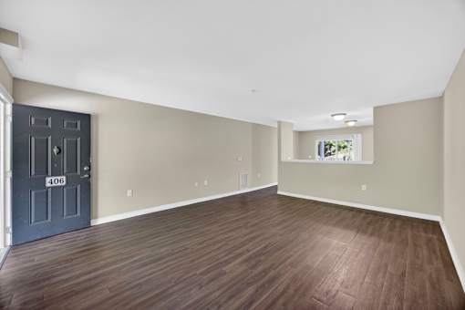 A room with a dark wood floor and a door with the number 406 on it.