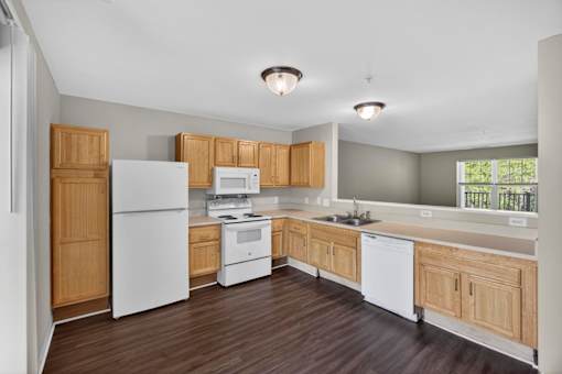 A kitchen with white appliances and wooden cabinets.