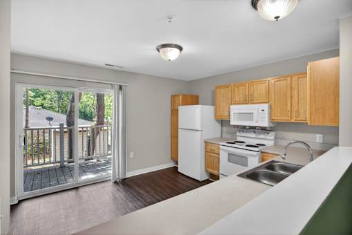 A kitchen with wooden cabinets and a white fridge.