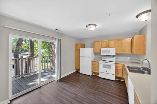 A kitchen with white appliances and wooden cabinets.