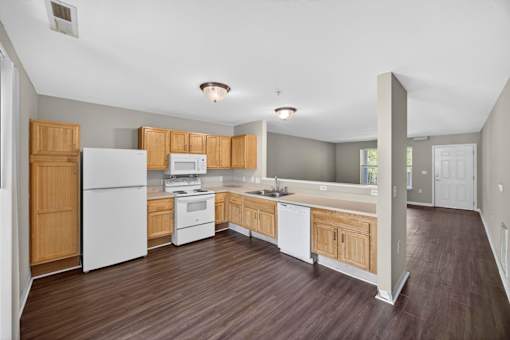 A kitchen with white appliances and wooden cabinets.