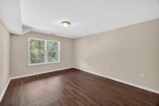 Empty room with wooden floor and a window.