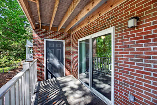 A red brick house with a black door and a glass window.