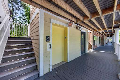 A yellow door is on the right side of a wooden staircase.