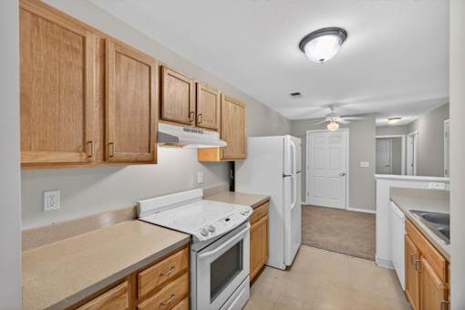 A kitchen with wooden cabinets and white appliances.