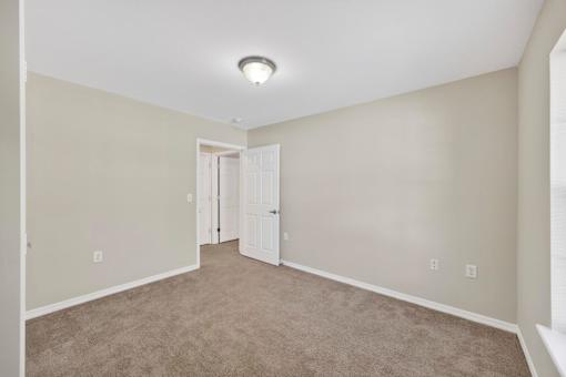 A room with a carpeted floor and a white ceiling light.