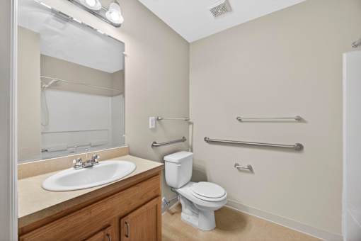 A white toilet sits next to a white sink in a bathroom.