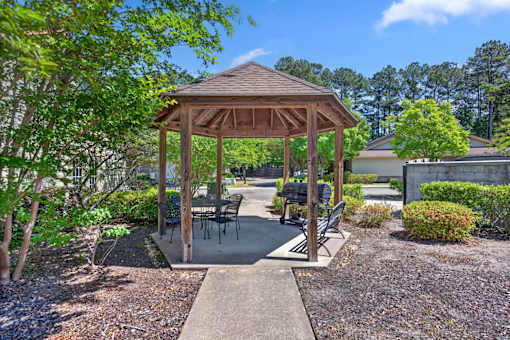 A gazebo with a concrete walkway in front of it.