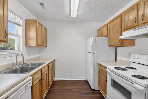 A kitchen with wooden cabinets and white appliances.