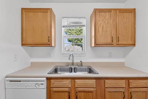 A kitchen with wooden cabinets and a dishwasher.