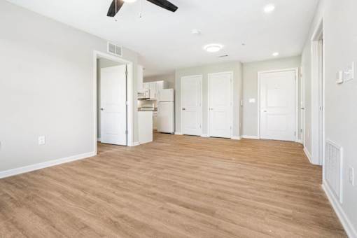 an empty living room and kitchen with a wood floor