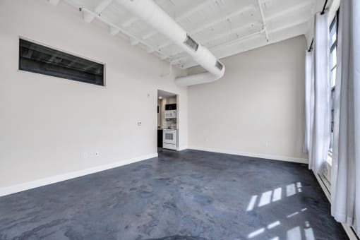 an empty room with white walls and a large window