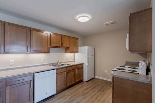 A kitchen with wooden cabinets and a white fridge.