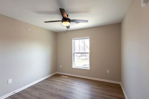 A room with a ceiling fan and a window.