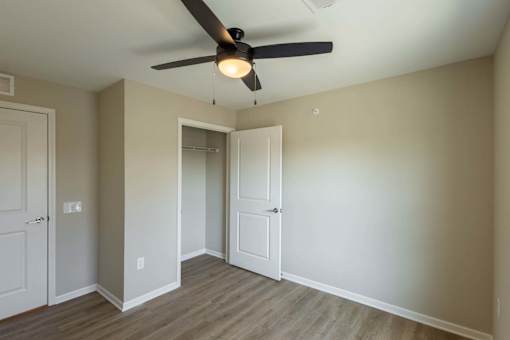 A room with a ceiling fan and two doors.
