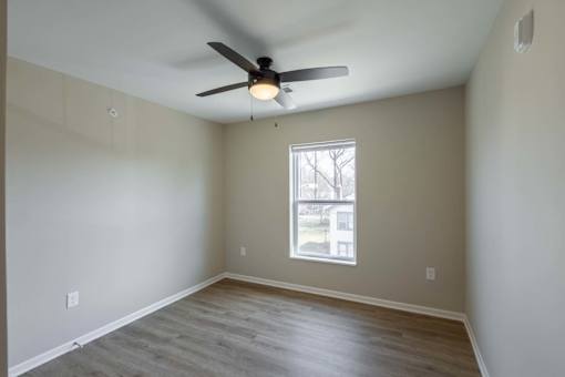 A room with a ceiling fan and a window.