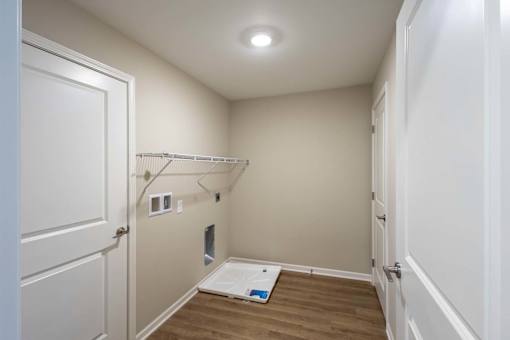 A small, empty room with a door on the left and a closet with a hanging rod.