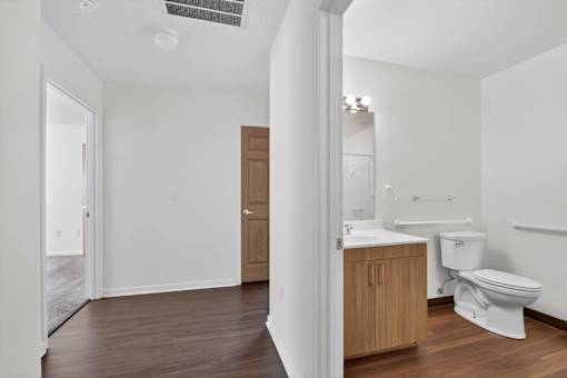 A white bathroom with a toilet, sink, and mirror.