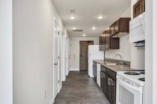 a kitchen with white appliances and a concrete floor