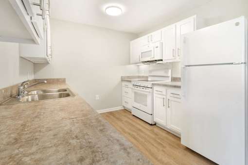 a kitchen with white appliances and white cabinets