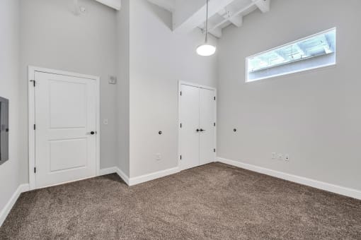 a bedroom with grey carpet and white walls