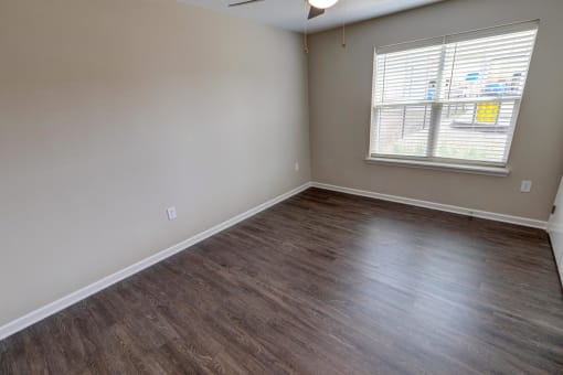 an empty room with a window and a ceiling fan