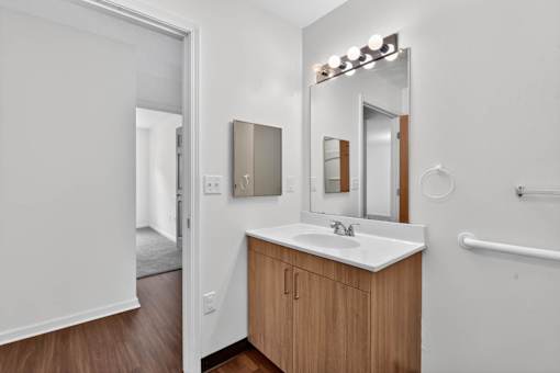 A bathroom with a sink, mirror, and a white door.