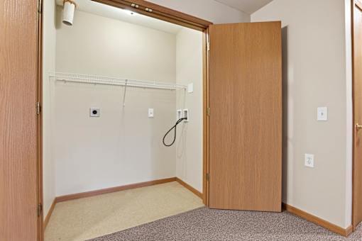 A room with a brown door and a white wall.