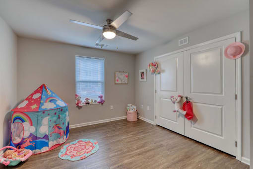 a playroom with a play tent and a ceiling fan