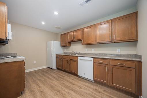 A kitchen with wooden cabinets and a white fridge.